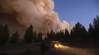 Gumpalan asap membubung di atas jalan raya saat kebakaran di Hutan Nasional Plumas, California (8/7/2021). Kebakaran kali ini merusak 91 bangunan. (AP Photo/Noah Berger)