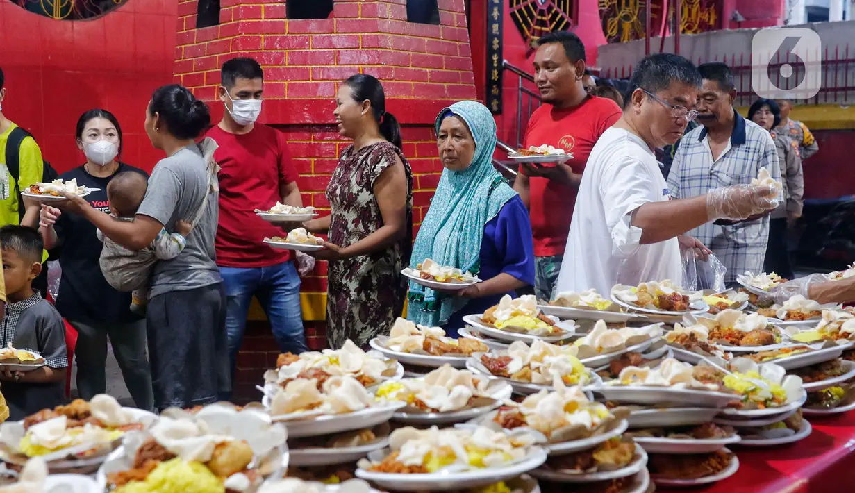 Panitia membagikan hidangan berbuka puasa di Vihara Dharma Bhakti, Petak Sembilan, Jakarta, Selasa (28/3/2023). (Liputan6.com/Angga Yuniar)