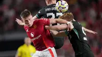 Gelandang Manchester United, Scott McTominay saat berduel dengan dua pemain Liverpool Luca Stephenson dan Sepp van den Berg dalam uji coba di Stadion William-Brice, Carolina Selatan, Minggu (4/8/2024). (GRANT HALVERSON / GETTY IMAGES NORTH AMERICA / Getty Images via AFP)