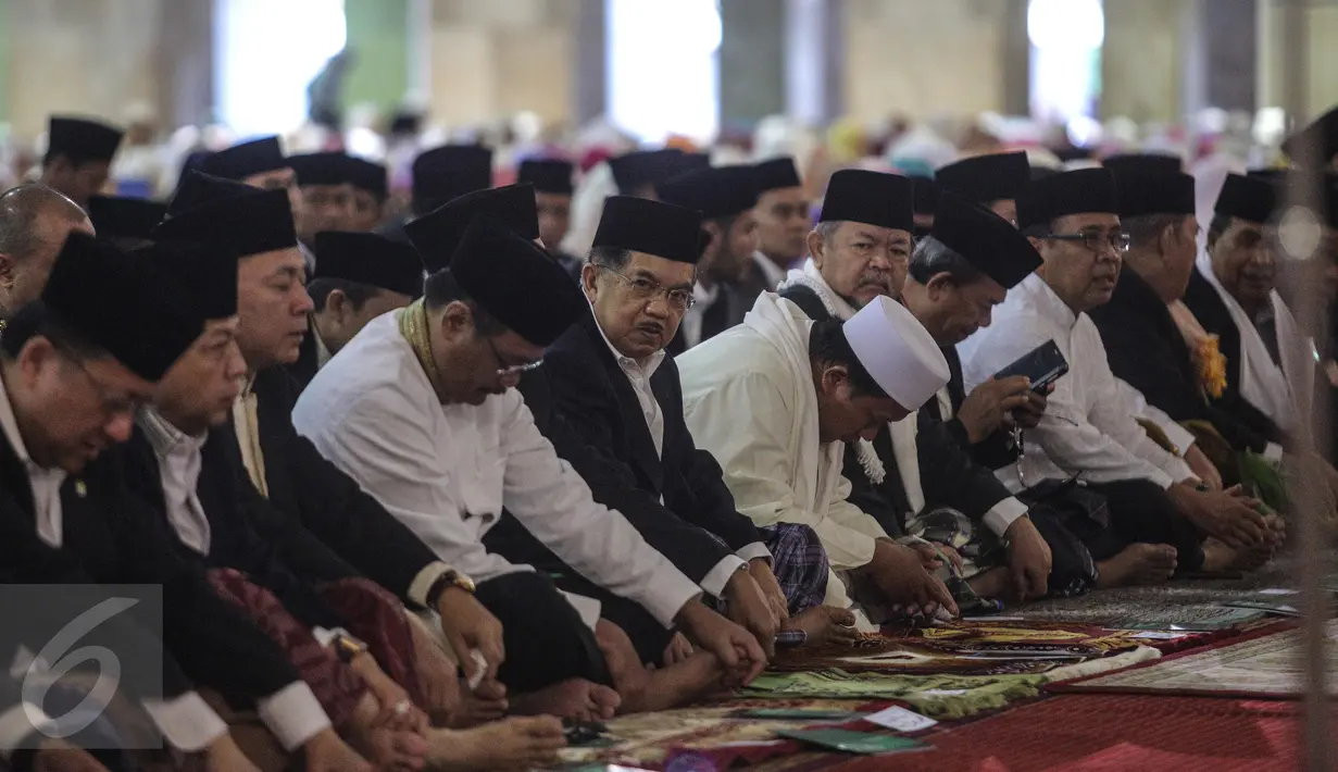 Wakil Presiden Jusuf Kalla (tengah) bersama ribuan umat muslim melakukan salat Idul Fitri di Masjid Istiqlal, Jakarta, Jumat (17/7/2015).  Tampak, Wakil Presiden Jusuf Kalla duduk bersama sejumlah pejabat tinggi negara. (Liputan6.com/Faizal Fanani)