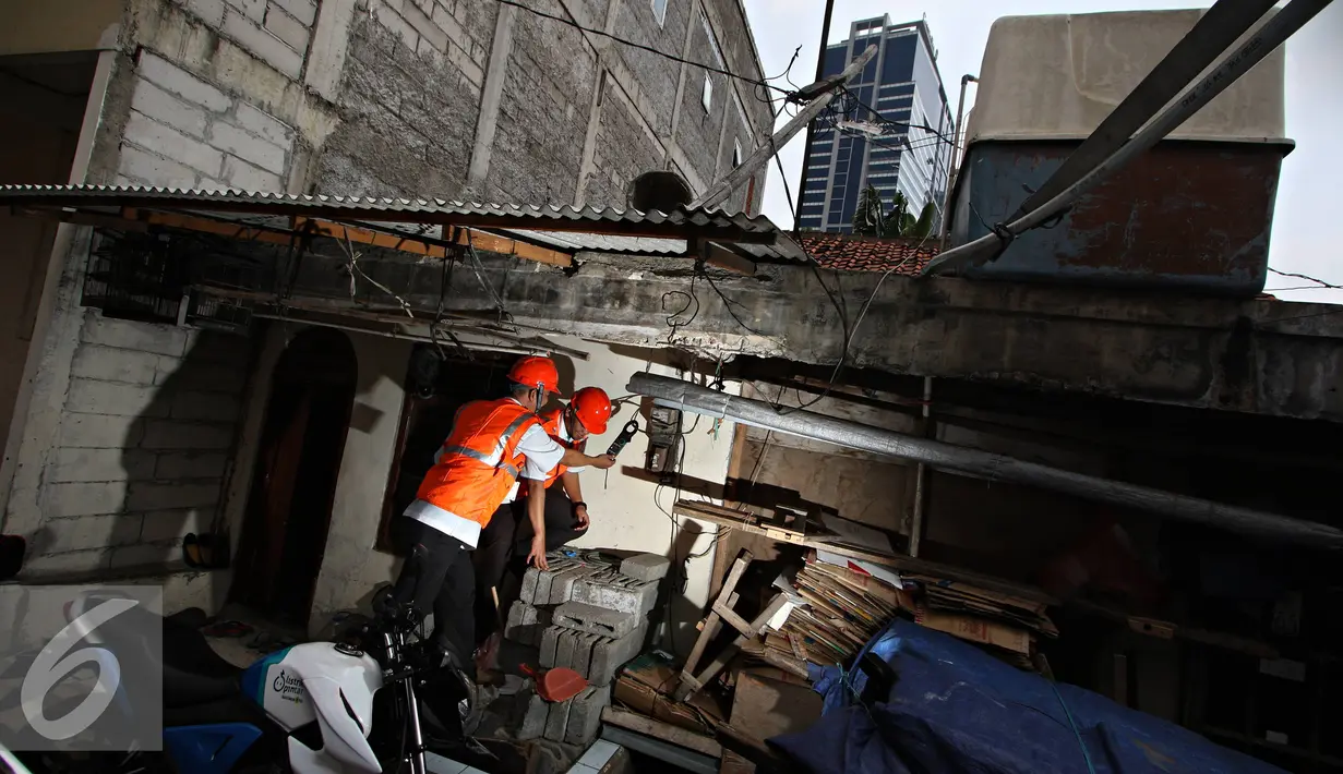 Petugas PLN Distribusi Jakarta Raya memeriksa tegangan pada alat pembatas dan pengukur di, Jakarta, Selasa (17/11). Pemerintah memutuskan tetap memberikan subsidi listrik pada seluruh pelanggan PLN dengan daya 450 VA. (Liputan6.com/Immanuel Antonius)