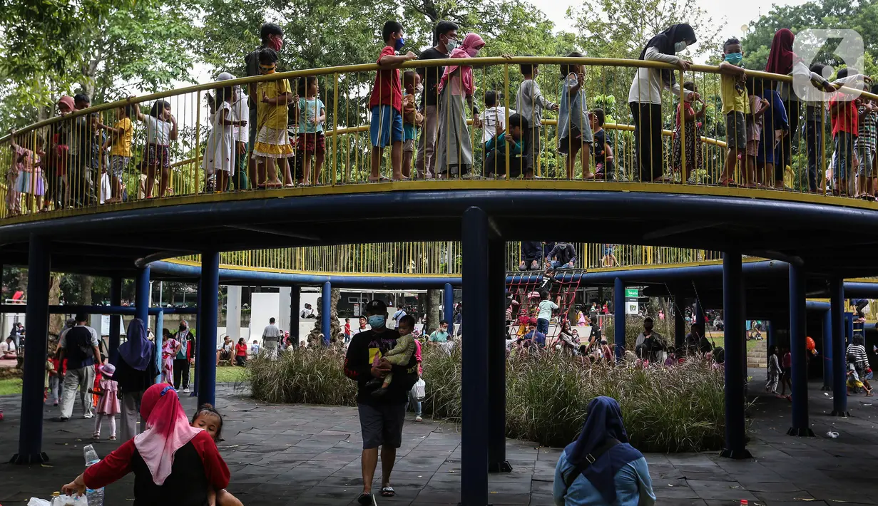 Anak-anak didampingi orang tua mereka bermain di Taman Puring, Jakarta, Minggu (9/1/2022). Di tengah ancaman penyebaran covid-19 varian Omicron dan pemberlakukan PPKM level 2, masyarakat tetap melakukan aktivitas pada akhir pekan di luar rumah. (Liputan6.com/Johan Tallo)