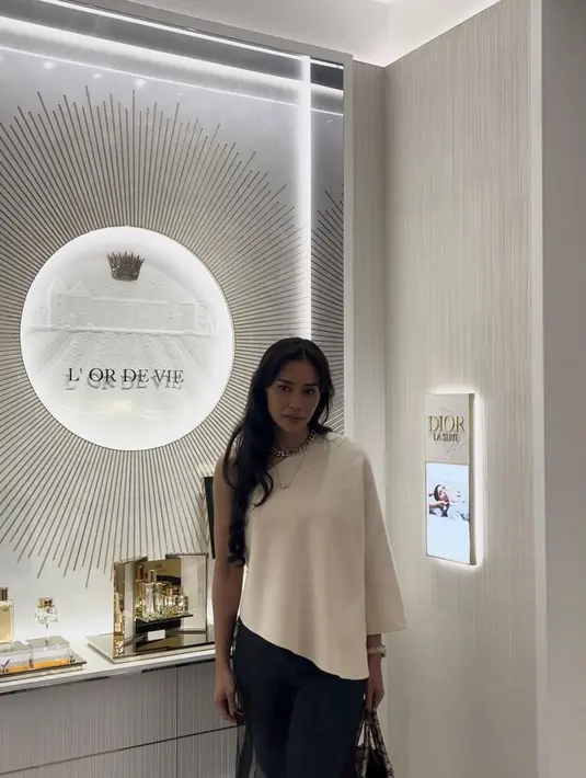 Adinia Wirasti memilik asymmetrical loose top yang dipadankan dengan jeans dan Dior Book Tote Bag.  / Foto dok: Fimela.