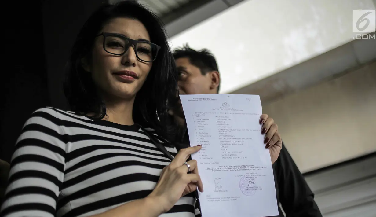 Artis peran Tyas Mirasih menunjukkan surat laporan pencemaran nama baik usai melapor ke Polda Metro Jaya, Jakarta, Rabu (21/3). Sebelumnya, Tyas dituduh menculik anak perempuan berusia lima tahun berinisial ACB. (Liputan6.com/Faizal Fanani)