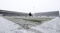 Salju dibersihkan dari lapangan sebelum pertandingan Liga Inggris antara Burnley dan Tottenham Hotspur di Turf Moor, Inggris, Minggu (28/11/2021). Laga Liga Inggris pekan ke-13 antara Burnley vs Tottenham ditunda. Pertandingan tersebut ditunda karena hujan salju lebat. (Bradley Collyer/PA via AP)