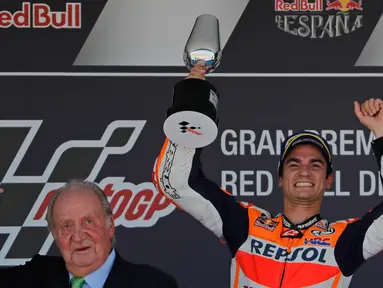 Pembalap Repsol Honda, Dani Pedrosa memegang trofi saat merayakan kemenangannya (kanan) pada balapan MotoGP Spanyol di Sirkuit Jerez, Minggu (7/5). Pedrosa finish terdepan dengan catatan waktu 45 menit 26,827 detik. (AP Photo/Miguel Morenatti)