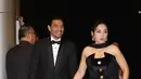 Hesti memilih strapless dress hitam dengan tambahan detail selendang di kerah, menciptakan siluet dramatis yang tetap anggun. Edi Borne hadir mendampingi dengan setelan jas hitam yang solid dan rapi, menjadi pasangan yang tampil stunning tanpa usaha berlebihan. [Dok/KLY/Budy Santoso].