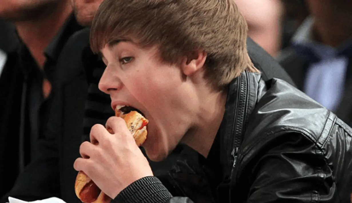 Justin Bieber pun kelihatan lahap banget ya menyantap hot dognya! (WeRSM)