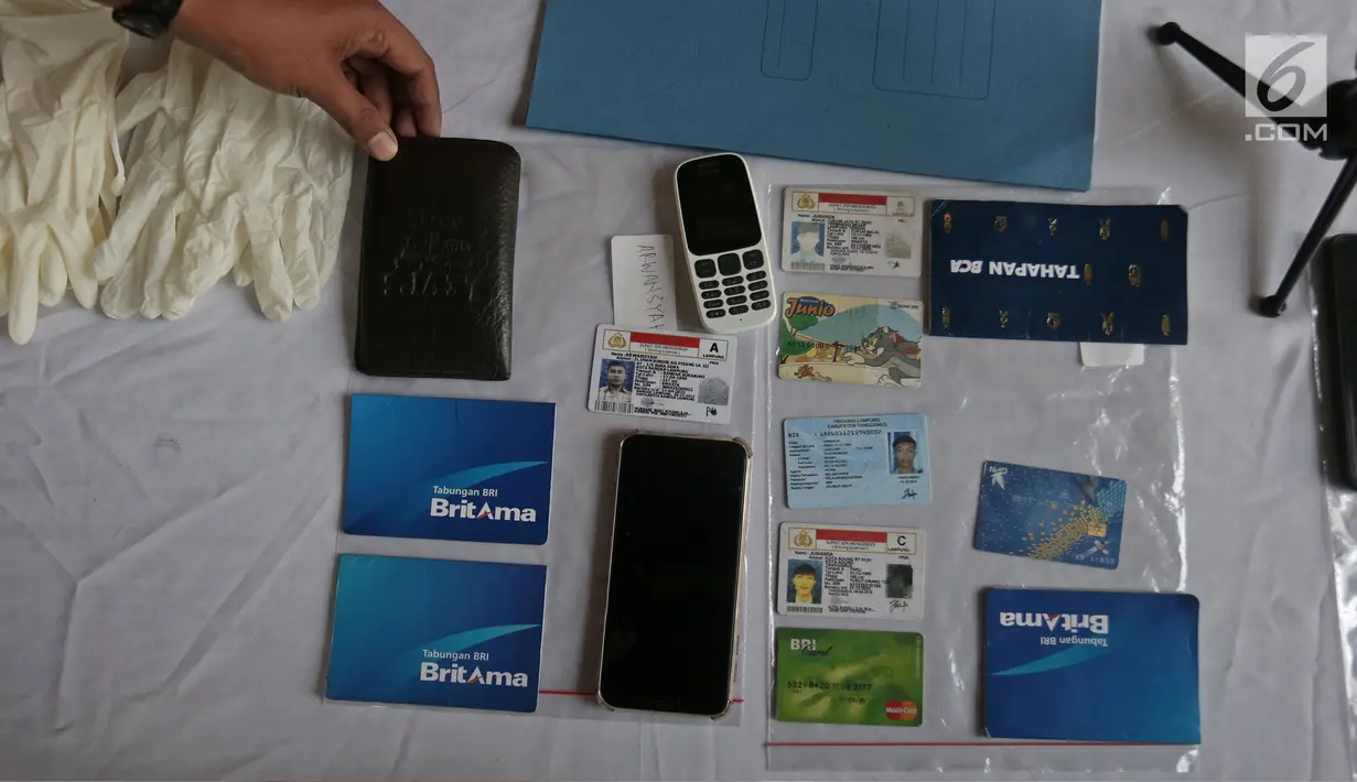 Petugas menunjukkan barang bukti saat rilis di Polda Metro Jaya, Jakarta, Rabu (19/6/2019). Polisi berhasil mengamankan sejumlah barang bukti seperti Hanphone, Kartu ATM, Uang Dolar dan Motor. (Liputan6.com/Herman Zakharia)