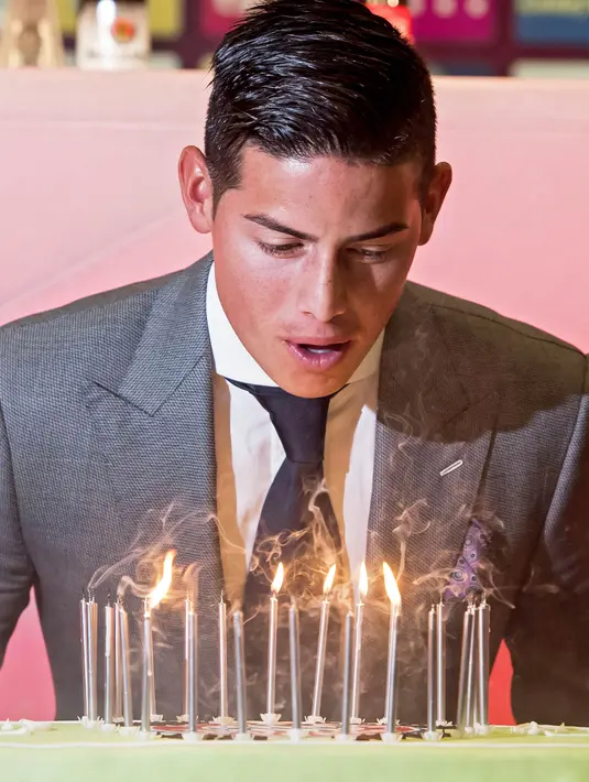Pemain baru Bayern Munchen, James Rodriguez, mendapatkan suprise kue ulang tahun saat perkenalan dirinya di Munchen, Rabu (12/7/2017). (EPA/Lukas Barth)