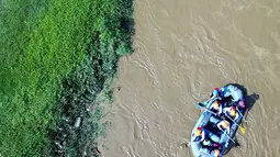 Peserta dengan perahu karet menyusuri Sungai Ciliwung sambil membersihkan sampah pada acara Bersih-Bersih Sungai Ciliwung, Jakarta, Minggu (08/4). Kegiatan tersebut dimaksudkan untuk memberi contoh kepada masyarakat sekitar. (Liputan6.com/Fery Pradolo)