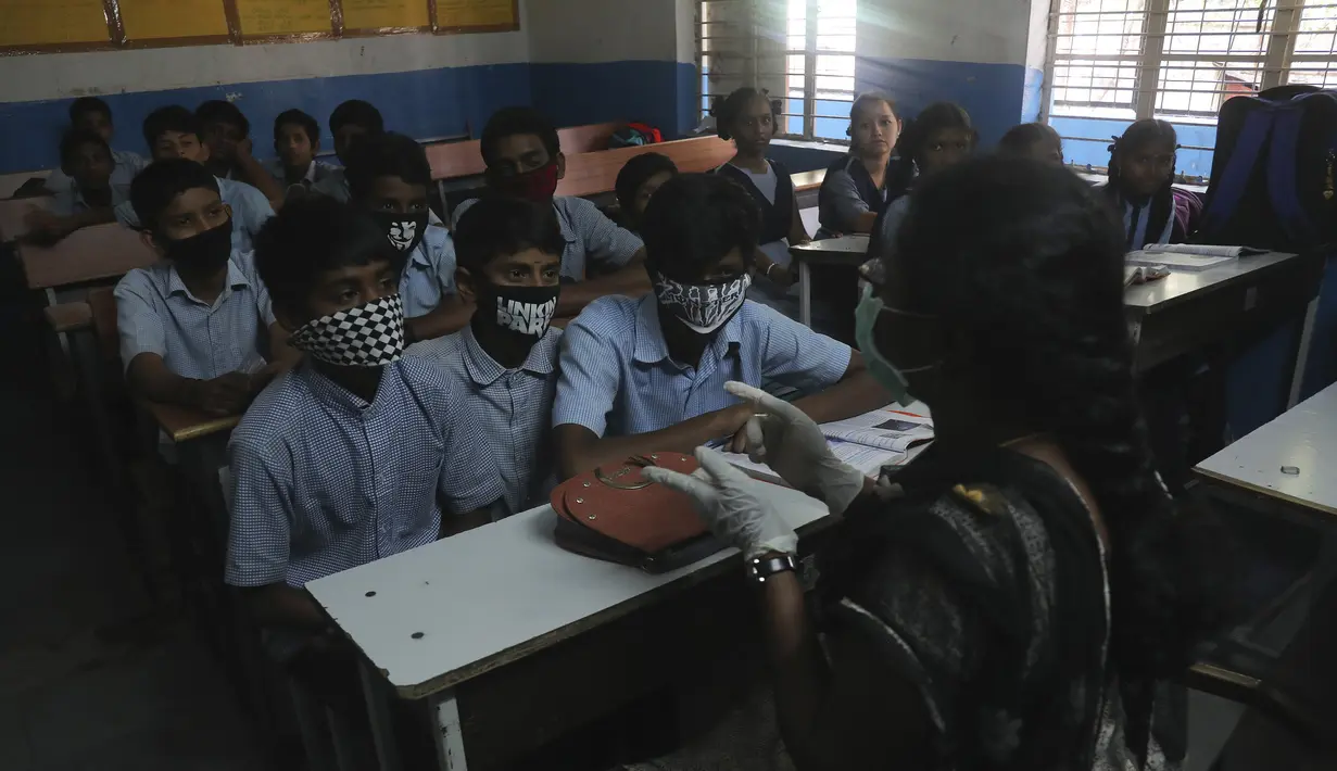 Sejumlah siswa mengenakan masker saat prose belajar mengajar di sebuah sekolah pemerintah di Hyderabad, India, Rabu (4/3/2020). Masker kini hal yang wajib digunakan siswa sejak virus corona memasuki wilayah India. (AP Photo/Mahesh Kumar A.)