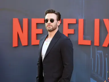 Aktor Chris Evans menghadiri pemutaran perdana film The Grey Man di TCL Chinese Theatre, Hollywood, California, Amerika Serikat, 13 Juli 2022. Evans tampak sangat ramah dalam blazer biru tua yang pas dan kalung liontin emas. (Leon Bennett/Getty Images for Netflix/AFP)
