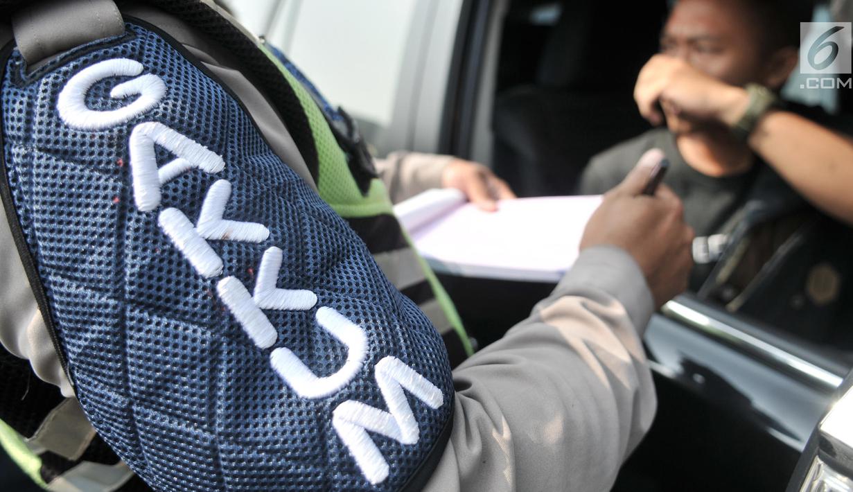 Polisi menilang pengendara yang melanggar pemberlakuan perluasan sistem ganjil genap di Jalan Salemba Raya, Jakarta, Senin (9/9/2019). Perluasan sistem ganjil genap kendaraan bermotor mulai diberlakukan hari ini. (merdeka.com/Iqbal Nugroho)