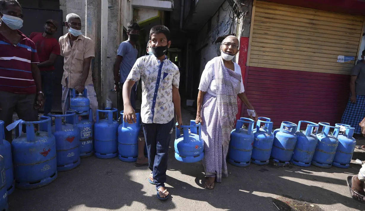 Warga Sri Lanka mengantre untuk mengisi ulang tabung gas memasak saat terjadi kekurangan pasokan di KolomboSelasa (4/1/2022). Antrean panjang selama berjam-jam telah menjadi pemandangan biasa dalam beberapa hari terakhir dalam upaya untuk membeli tabung gas domestik. (AP Photo/Eranga Jayawardena).