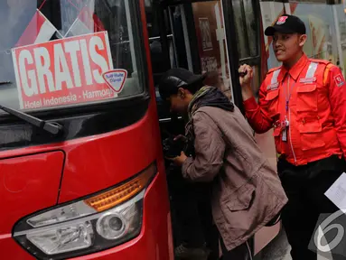 Seorang penumpang menaiki bus gratis di Thamrin, Jakarta, Rabu (17/12/2014). (Liputan6.com/Faizal Fanani)
