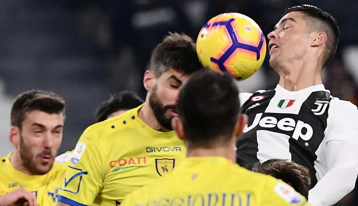 Bek Chievo, Luca Rossettini penyerang Juventus, Cristiano Ronaldo duel udara pada laga pekan ke-20 Serie A di Allianz Stadium, Senin (21/1). Juventus berhasil memantapkan posisi di puncak klasemen setelah menggilas Chievo 3-0. (Marco BERTORELLO/AFP)