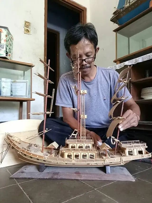 Perajin, Iping, sedang membuat miniatur perahu khas Purwakarta. (Foto: Liputan6.com/Asmul)