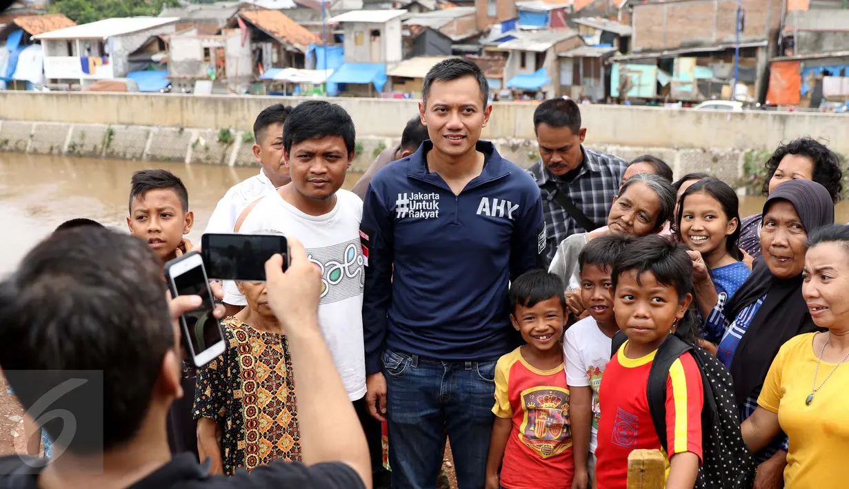 Bakal Calon Gubernur DKI, Agus Harimurti Yudhoyono berfoto bersama sejumlah warga saat mengunjungi kawasan Bukit Duri, Jakarta, Kamis (20/10). Kunjungan Agus Yudhoyono untuk melihat langsung kondisi warga yang terkena gusuran (Liputan6.com/Gempur M Surya)