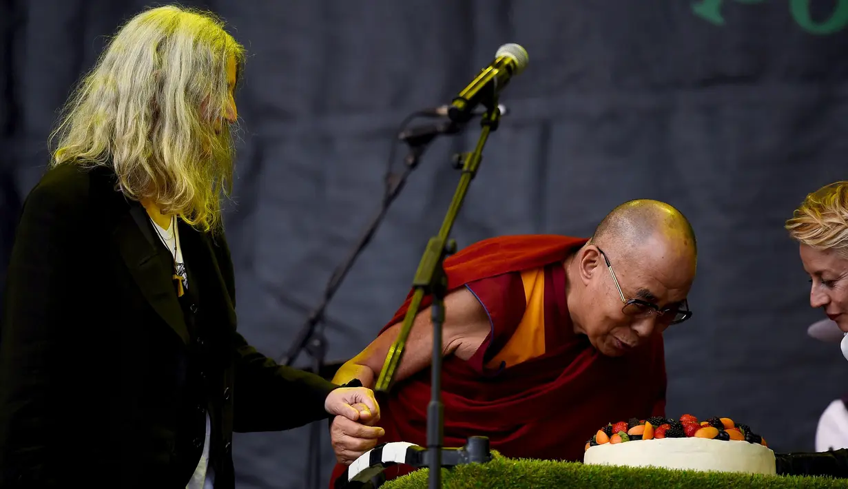 Musisi, Patti Smith (kiri) menyaksikan Dalai Lama meniup kue ulang tahun saat acara Glastonbury Festival, Inggirs, (28/6/2015). (REUTERS/Dylan Martinez)
