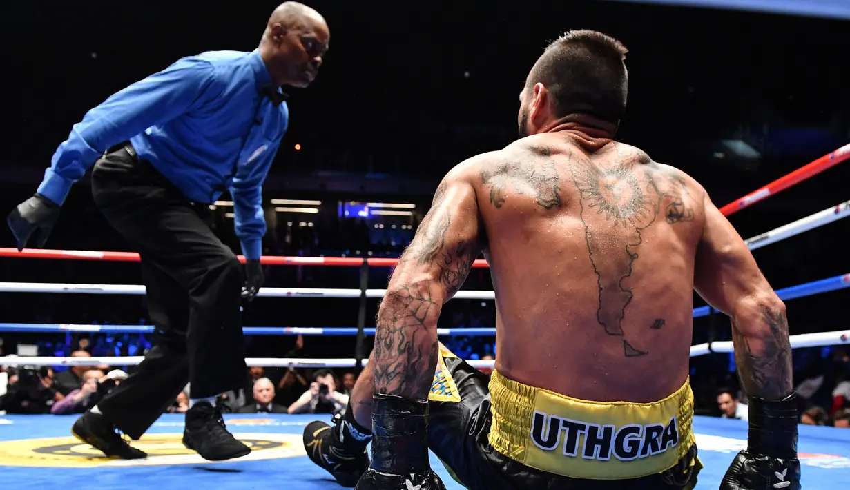 Petinju Argentina, Lucas Matthysse terjatuh saat melawan petinju Filipina Manny Pacquiao saat bertanding pada kelas welter versi WBA di Axiata Arena di Kuala Lumpur, Malaysia (15/7). Pacquiao menang KO atas Matthysse di Ronde ke 7. (AFP Photo/Mohd Rasfan)