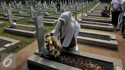 Seorang warga memberikan karangan bunga saat ziarah di TMP Kalibata, Jakarta, Minggu (1/11/2015). Mereka akan membongkar makam keluarga mereka di TMP jika pemerintah melakukan penggusuran terhadap rumah mereka. (Liputan6.com/Johan Tallo)