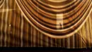 Siluet seorang pria muncul melalui tirai emas tembus pandang yang dipasang di Hollywood Blvd. untuk kedatangan Academy Awards ke-94 hari Minggu, di Los Angeles, Rabu (23/3/2022). Piala Oscar 2022 akan diadakan pada Minggu, 27 Maret 2022 di Dolby Theatre Hollywood. (AP Photo/Chris Pizzello)