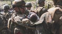 Seorang Penerbang menghibur seorang bayi selama mengungsi di Bandara Internasional Hamid Karzai di Kabul, Afghanistan, Jumat (20/8/2021). Hingga Jumat (20/8/2021), ribuan warga Afghanistan yang putus asa masih terus berkumpul di bandara Kabul. (Sgt. Isaiah Campbell/U.S. Marine Corps via AP)
