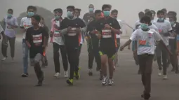 Para peserta mengikuti lomba lari New Delhi 10K menggunakan masker ditengah-tengah kabut polusi yang menimpa kota New Delhi, India (6/11). Kabut polusi ini menimbulkan partikel yang menggangu kesehatan. (AFP/Dominique Faget)