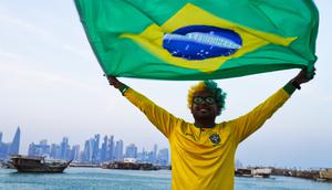 Penggemar timnas Brasil, Ajmal Pial dari Khulna, Bangladesh, mengibarkan bendera timnas kesayangannya di Doha, Qatar, Jumat (18/11/2022). Para penggemar membanjiri Qatar pada hari Jumat menjelang Piala Dunia pertama di Timur Tengah ketika tuan rumah memutuskan untuk melarang penjualan bir di stadion selama gelaran tersebut - dalam perubahan mengejutkan di menit-menit terakhir yang disambut oleh Muslim konservatif negara itu. (AP Photo/Jon Gambrell)