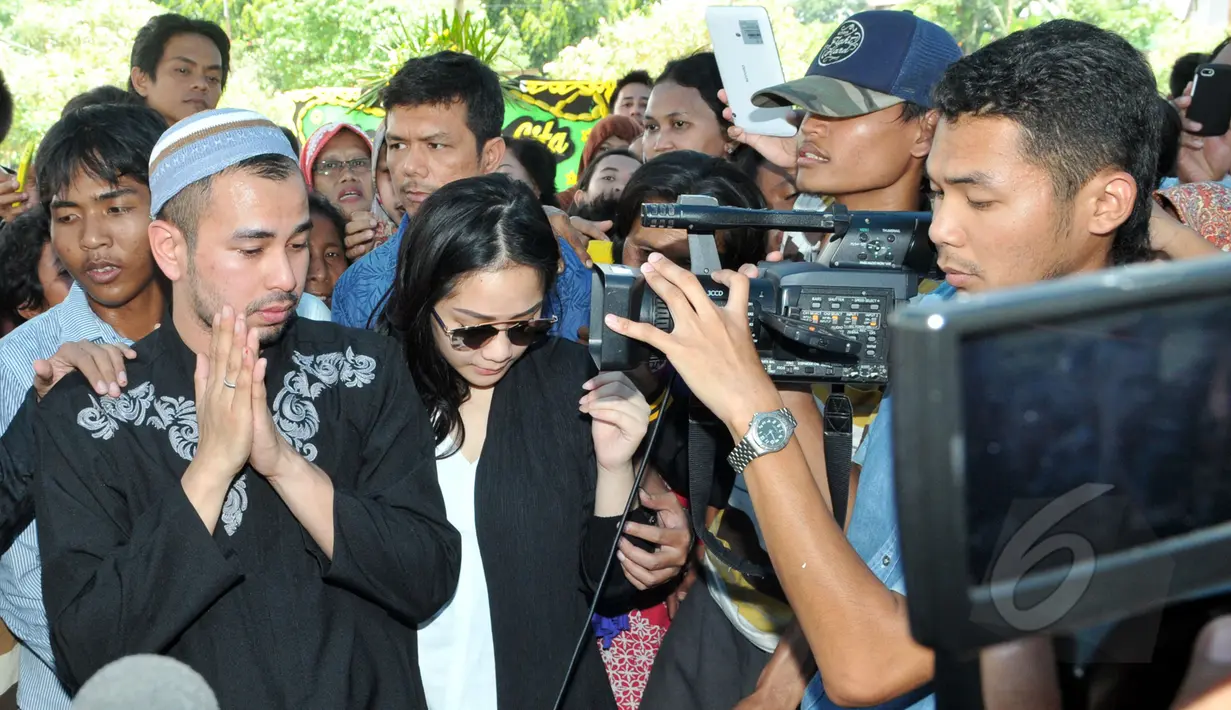 Aktor sekaligus presenter Raffi Ahmad tampak ditemani sang istri, Nagita Slavina (Gigi) saat berziarah ke makam Olga Syahputra di TPU Malaka, Pondok Kelapa, Jakarta, Selasa (31/3/2015). (Liputan6.com/Panji Diksana) 
