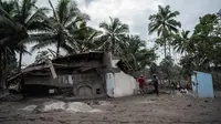 Penduduk desa menyelamatkan apa yang mereka dapat dari rumah mereka yang rusak akibat erupsi Gunung Semeru di Desa Sumber Wuluh, Lumajang, Jawa Timur, Senin (6/12/2021). Desa Sumber Wuluh luluh lantak mengakibatkan puluhan rumah rusak dan ratusan warga mengungsi. (Juni Kriswanto/AFP)