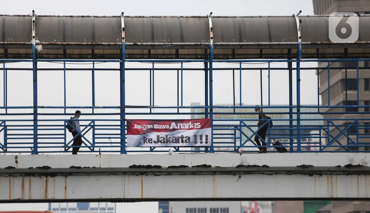 Spanduk imbauan tolak anarkisme terpasang di JPO di Jakarta, Minggu (11/10/2020). Spanduk imbauan untuk tidak melakukan aksi anarkisme merebak di sejumlah kawasan di Jakarta pascaaksi unjuk rasa massa yang menolak pengesahan Omnibus Law UU Cipta Kerja. (Liputan6.com/Faizal Fanani)