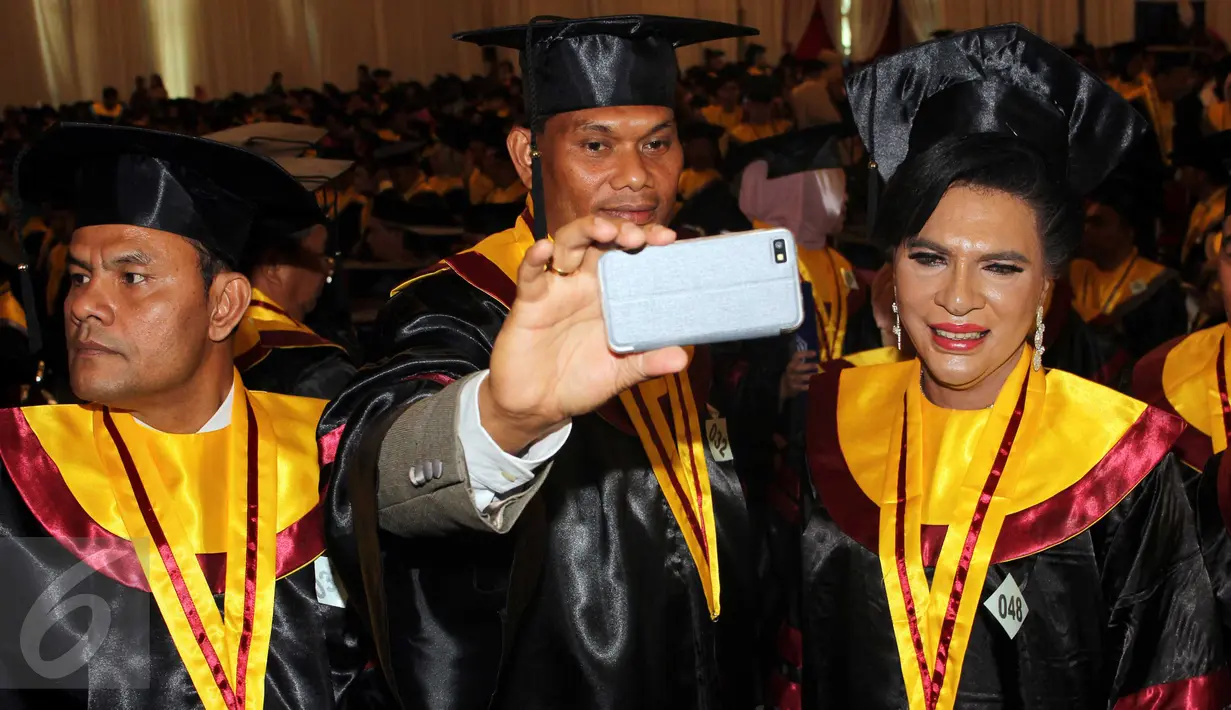 Aktivis Waria Indonesia, Yulianus Rettoblaut alias Mami Yuli (tengah)berselfie usai acara wisuda di sebuah perguruan tinggi di Jakarta Selatan, Rabu (9/9). Mami Yuli berhasil meraih gelar Master Hukum dengan predikat terbaik. (Liputan6.com/Helmi Afandi)