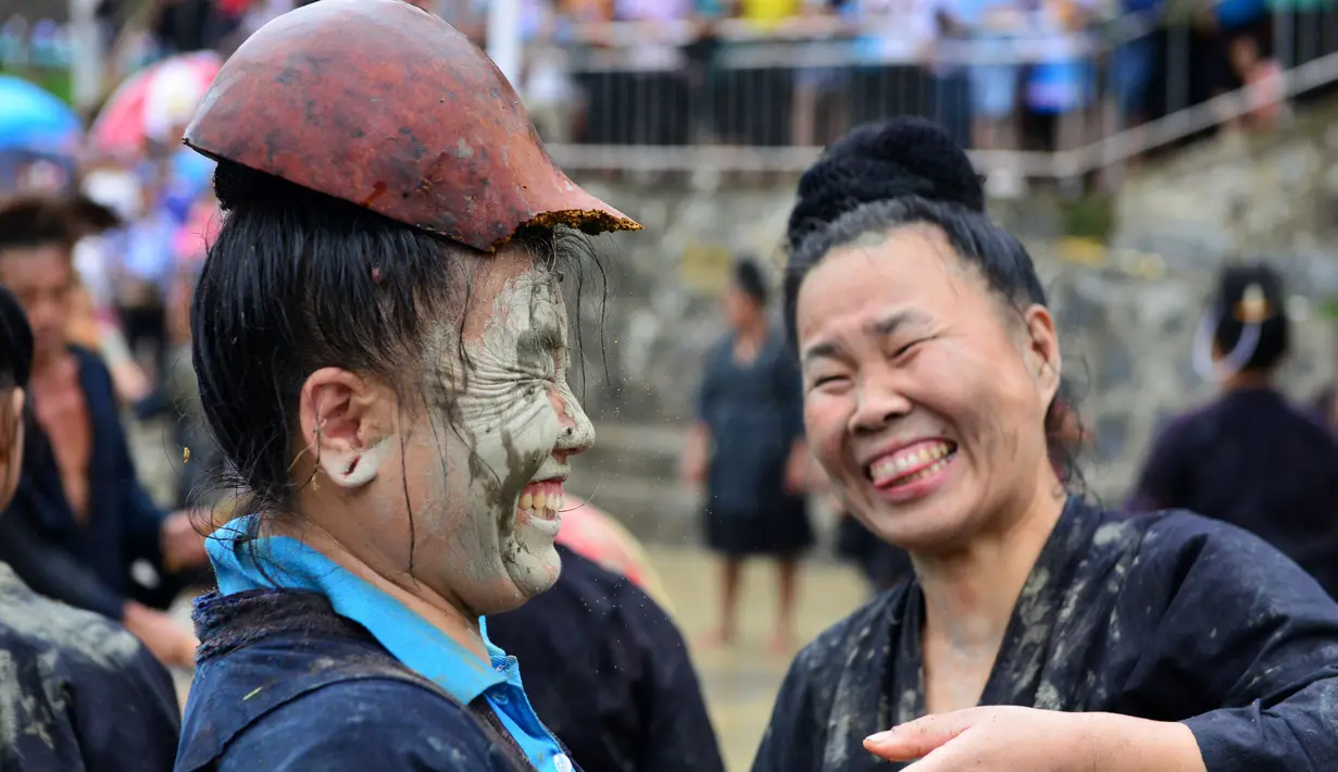 Ekspresi peserta yang wajahnya dilumuri lumpur saat mengikuti festival dog carrying day di provinsi Guizhou, Tiongkok (2/9). Acara ini dimaksudkan untuk menunjukkan kepercayaan mereka tentang kesetaraan semua makhluk. (AFP Photo/STR/China Out)