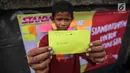 Seorang anak menunjukan tulisan cita-citanya  di jalur banjir kanal barat Tanah Abang, Jakarta, Senin (31/7). Selain itu kegiatan tersebut juga untuk menyambut bulan kemerdekaan RI. (Liputan6.com/Faizal Fanani)