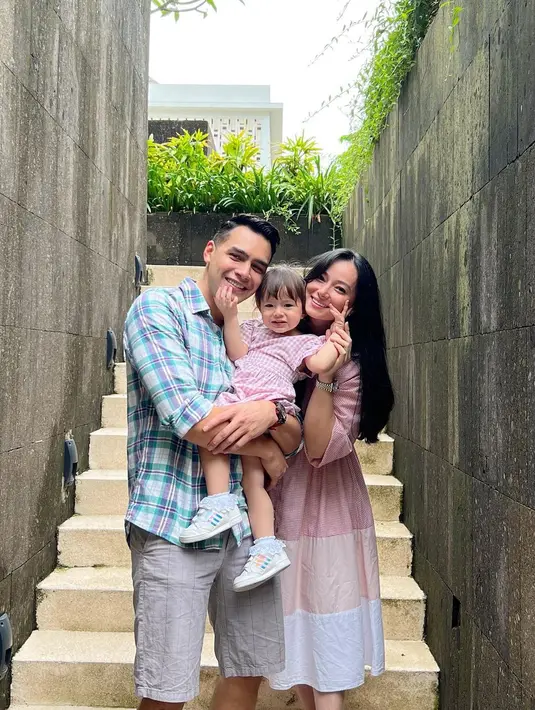 Mengunggah dua foto di akun Instagram terverifikasinya pada 7 Oktober 2022, Asmirandah berpose menggendong Chloe di tangga. Ia mengenakan gaun tiga warna yakni dusty pink, pinggala, dan putih yang mengembang di bagian bawah. Chloe kompak dengan ayahnya pakai baju kotak-kotak. Jonas Rivanno memadukan kemeja lengan panjang kotak-kotak dengan celana pendek saliwah. (Foto: Dok. Instagram @asmirandah89)