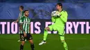 Kiper Real Madrid, Thibaut Courtois (kanan) menangkap bola dari ancaman striker Real Betis, Aitor Ruibal dalam laga lanjutan Liga Spanyol 2020/2021 pekan ke-33 di Alfredo Di Stefano Stadium, Madrid, Sabtu (24/4/2021). Real Madrid bermain imbang 0-0 dengan Real Betis. (AFP/Gabriel Bouys)