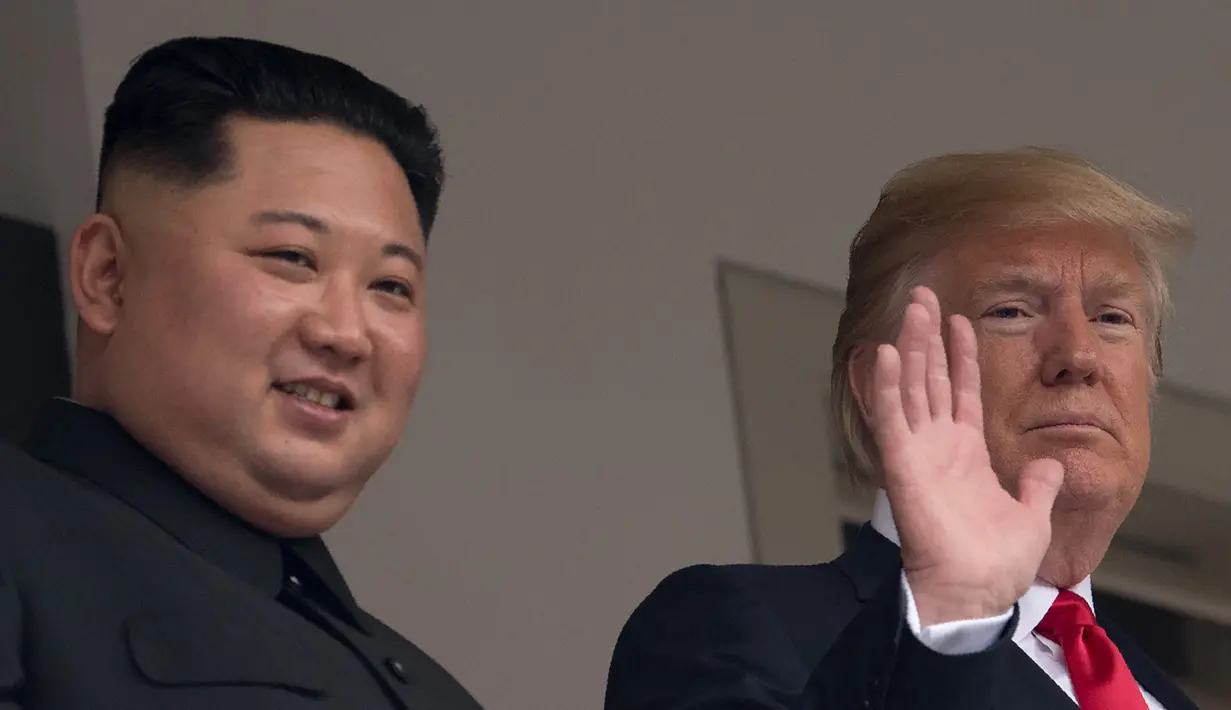 Presiden AS Donald Trump (kanan) melambaikan tangan saat tampil bersama Pemimpin Korea Utara Kim Jong-un di balkon Hotel Capella, Pulau Sentosa, Singapura, Selasa (12/6). Trump dan Kim telah bertemu untuk pertama kalinya. (SAUL LOEB/AFP)