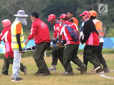 Petugas mengevakuasi atlet paralayang putri asal Malaysia Sharifah Nadiah Wafa saat bertanding pada nomor ketepatan mendarat Asian Games 2018, Bogor (21/8). Sharifah diduga mengalami cedera bagian pinggul kaki kanan ke bawah. (Merdeka.com/Arie Basuki)