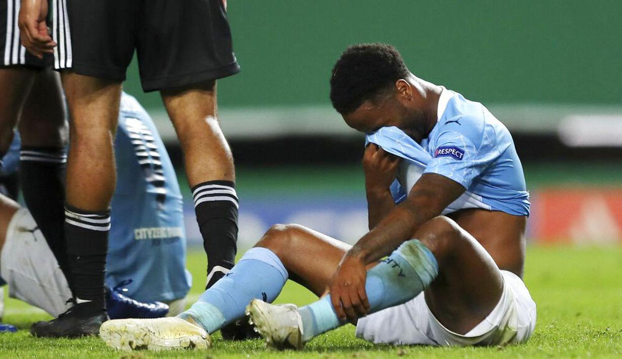 Pemain Manchester City, Raheem Sterling, menutup wajahnya usai ditaklukkan Lyon pada perempat final Liga Champions di Stadion Jose Alvalade, Sabtu (15/8/2020). Lyon menang 3-1 atas Manchester City. (Miguel A. Lopes/Pool via AP)