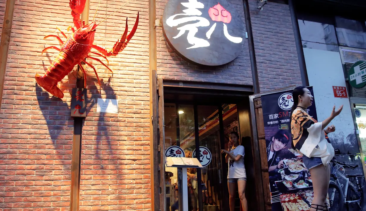 Pemilik restoran Ke'er, Lu Lu (27) berbincang dengan pengunjung di depan rumah makan miliknya yang telah dibangun sejak satun lalu tersebut di Beijing, China, (26/5). (REUTERS/Kim Kyung-Hoon)