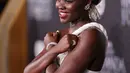 Lupita Nyong'o berpose saat menghadiri pemutaran perdana film Black Panther: Wakanda Forever" di Dolby Theatre di Los Angeles pada Rabu, 26 Oktober 2022. Rambut brunette-nya ditata dengan twist updo yang beraksen dengan ikat kepala yang terbuat dari kerang. (Jesse Grant/Getty Images for Disney/AFP)