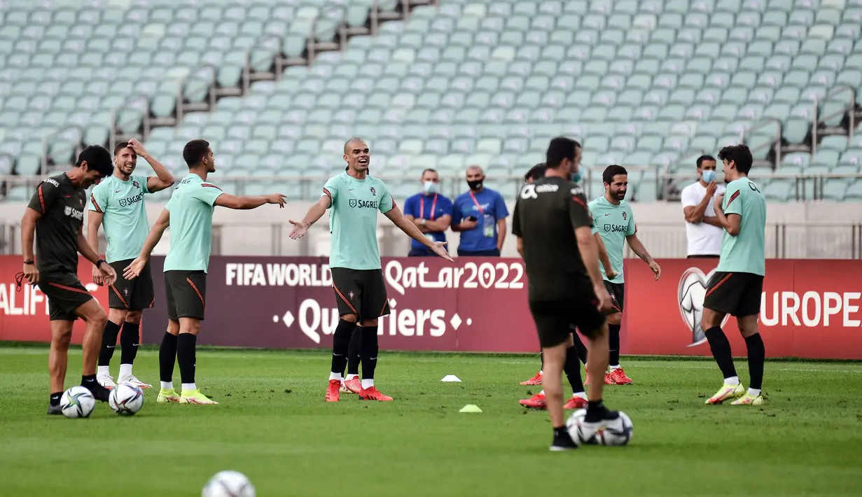 Bek Portugal, Pepe (tengah) dan rekan satu timnya melakukan pemanasan dalam sesi latihan di Baku (6/9/2021). Portugal sementara menempati peringkat dua dengan 10 poin. (AFP/Toflik Babayev)