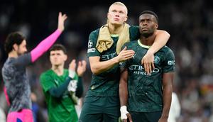 Erling Haaland (kiri) dan Marc Guehi dari Manchester City berjalan keluar lapangan setelah pertandingan leg pertama babak 16 besar Liga Champions antara Real Madrid dan Manchester City di Madrid, Spanyol, Kamis (12-3-2026) dini hari WIB. (AP Photo/Jose Breton)