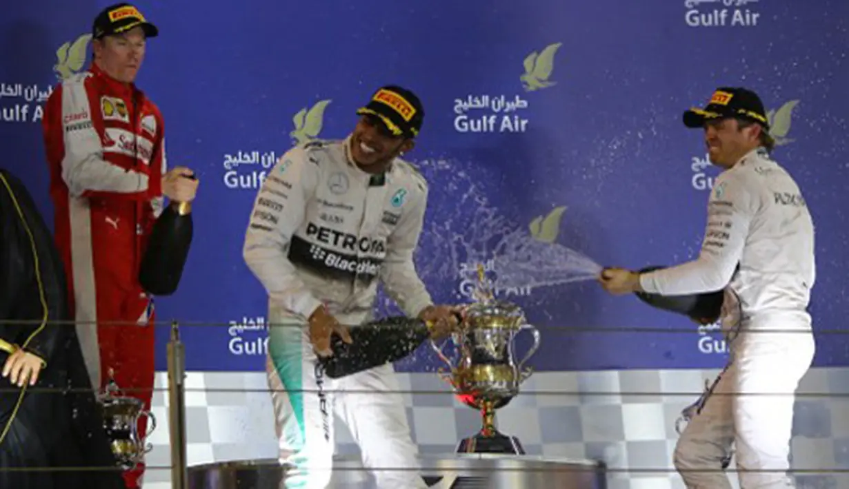 Lewis Hamilton (tengah) menyemprotkan sampanye kea rah peringkat tiga, Nico Rosberg (kanan), dan Kimi Raikkonen dari Ferrari. (photo by AFP/MARWAN NAAMANI)