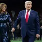 Melania Trump dan Donald Trump saat menghadiri College Football Playoff National Championship di Mercedes-Benz Superdome, New Orleans, Louisiana, AS. (SAUL LOEB / AFP)
