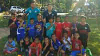 Kiper Arema, Joko Ribowo (kanan), bersama anak-anak dari JRFA di Pati, Jawa Tengah. (Bola.com/Iwan Setiawan)