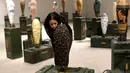 Seorang pengunjung melihat-lihat replika bom warna-warni karya seniman Lebanon, Katya Traboulsi saat dipamerkan di Salih Barakat Gallery, Beirut, Selasa (10/4). (ANWAR AMRO/AFP)