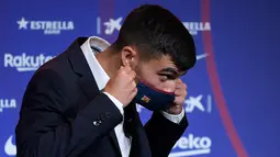 Penyerang baru Barcelona Pedri mengenakan masker selama presentasi resminya di stadion Camp Nou di Barcelona (20/8/2020). Pedri bermain di posisi winger kiri saat di Las Palmas. (AFP/Josep Lago)